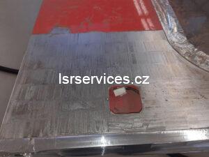 Pohled na dveře vozu MHD, které právě procházejí laserovým čištěním, V přední části obrázku je část dveří, která už čištěním prošla.