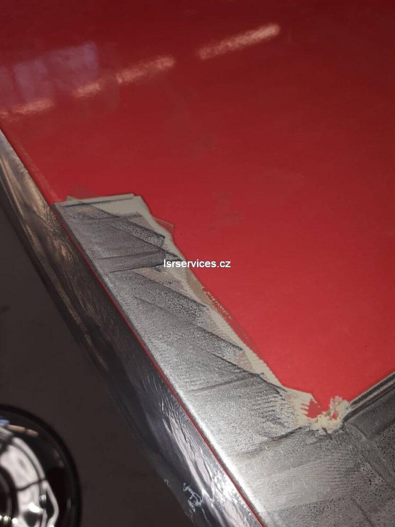 Detailní pohled na rozdíl mezi částmi bez laku, kde už čištění laserem proběhlo, a částí s lakem, která na laserové čištění teprve čeká.