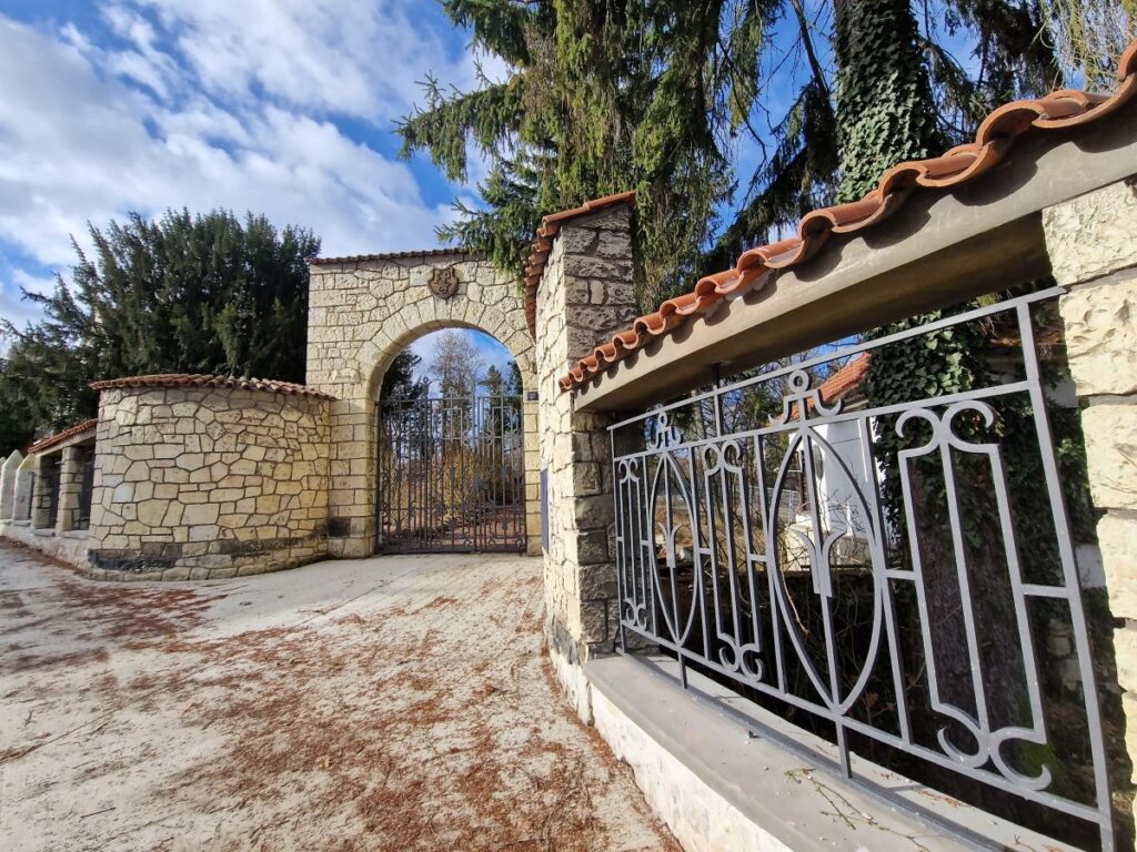 Zrekonstruovaná vstupní brána parku s opukovým zdivem a novými ocelovými mřížemi po renovaci od LSR Services